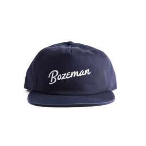 Customizable navy blue cap with 'Bozeman' script text on a white background